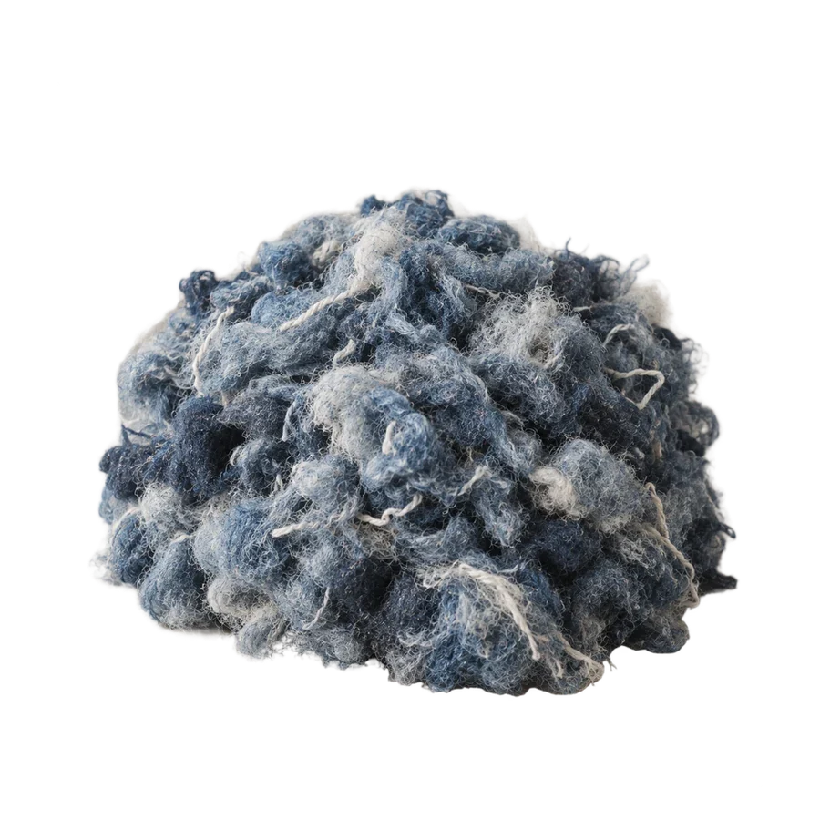 A soft heap of recycled blue cotton fibre.
