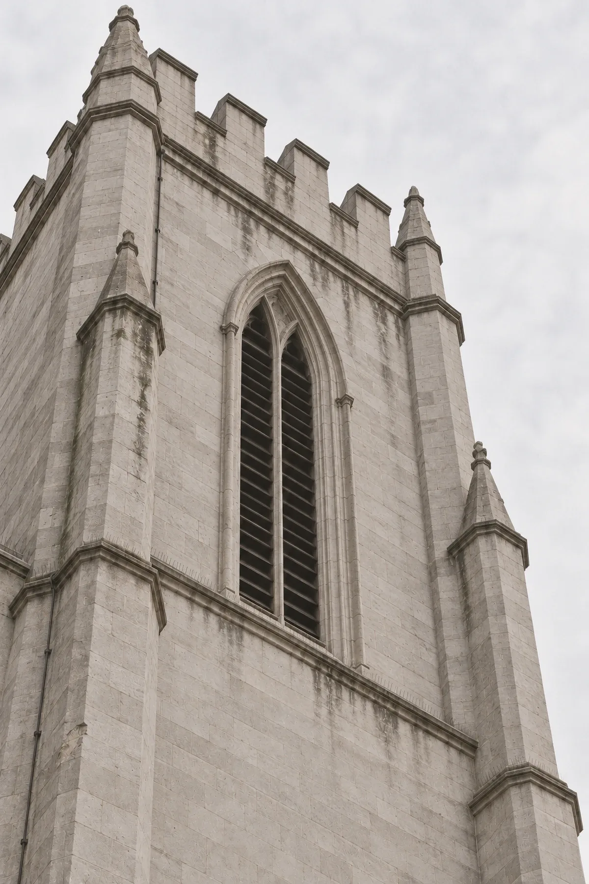 Looking up at a grey limestone tower of the Notre-Dame Basilica in Montreal.